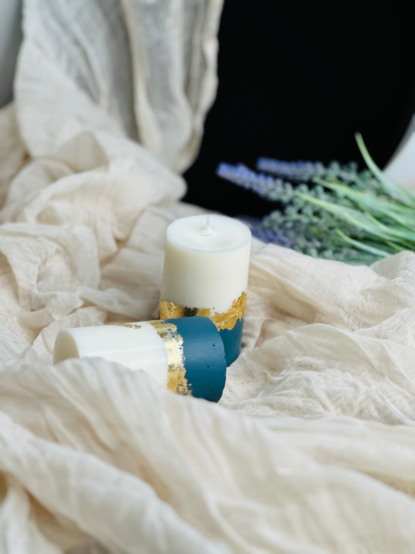 Decorative candle with gold and blue accents on a white fabric background - UK made