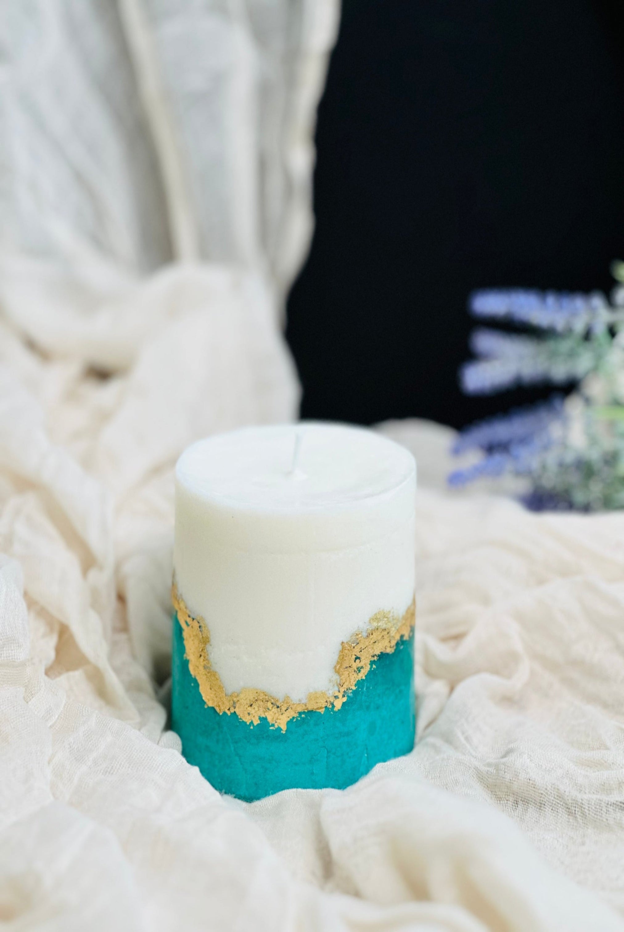 A white soy wax candle with teal concrete base made in UK