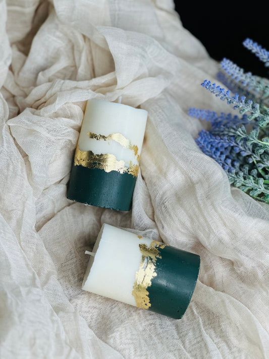 Two candles with gold accents on a textured white fabric background with lavender flowers - UK made