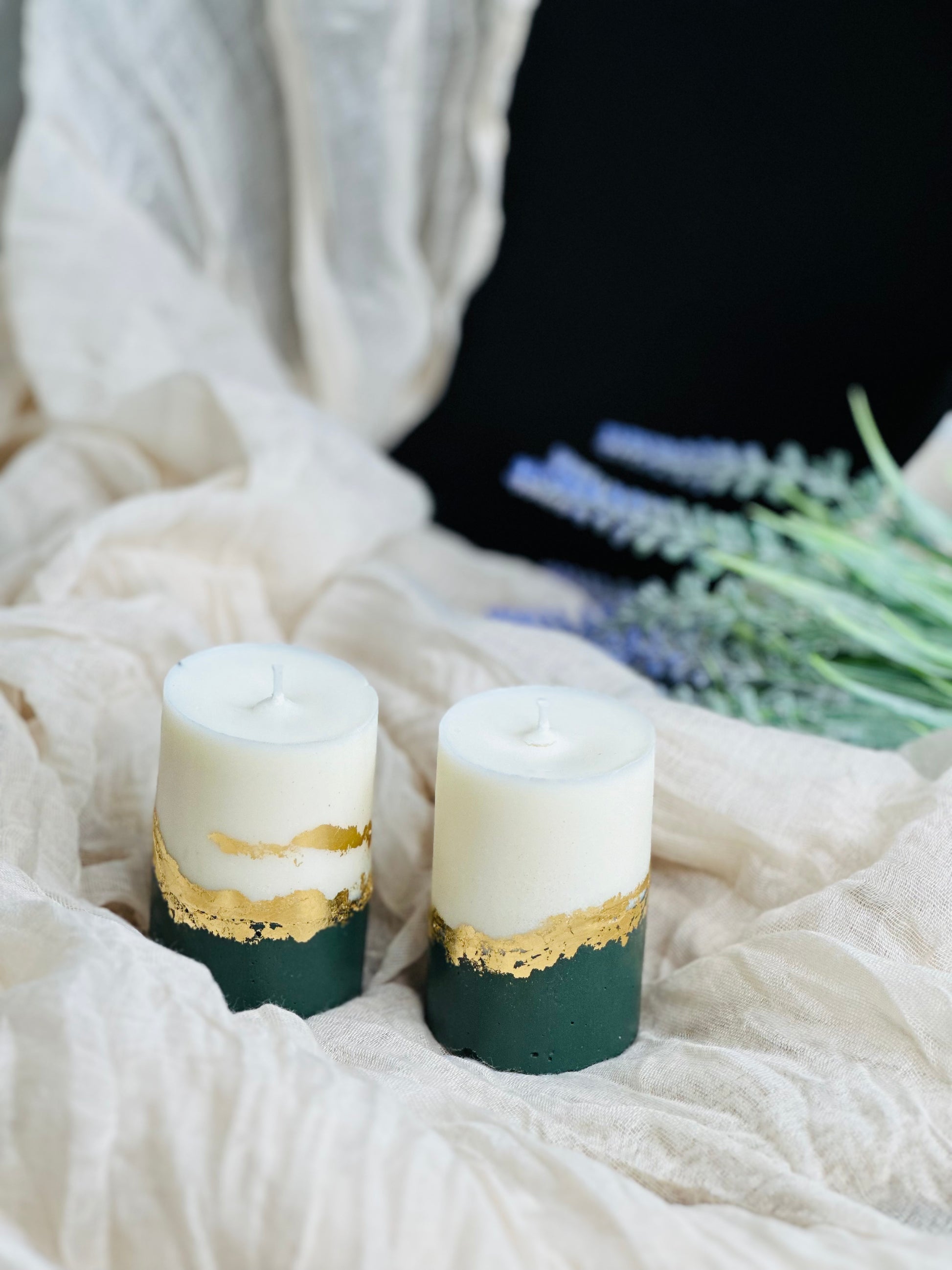 Two candles with gold accents on a white fabric background - UK made