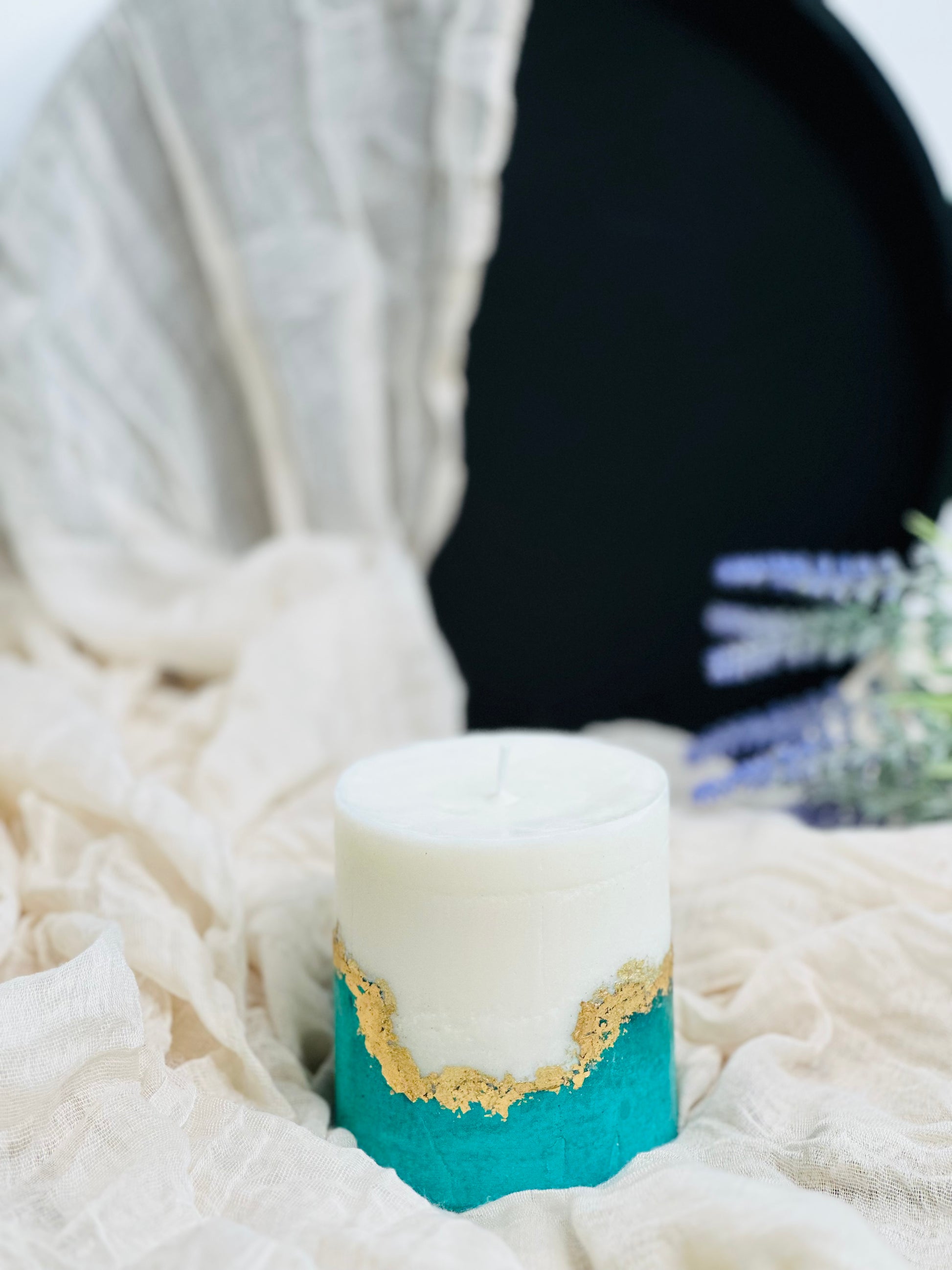 Decorative candle with gold and blue accents on a textured surface made in UK