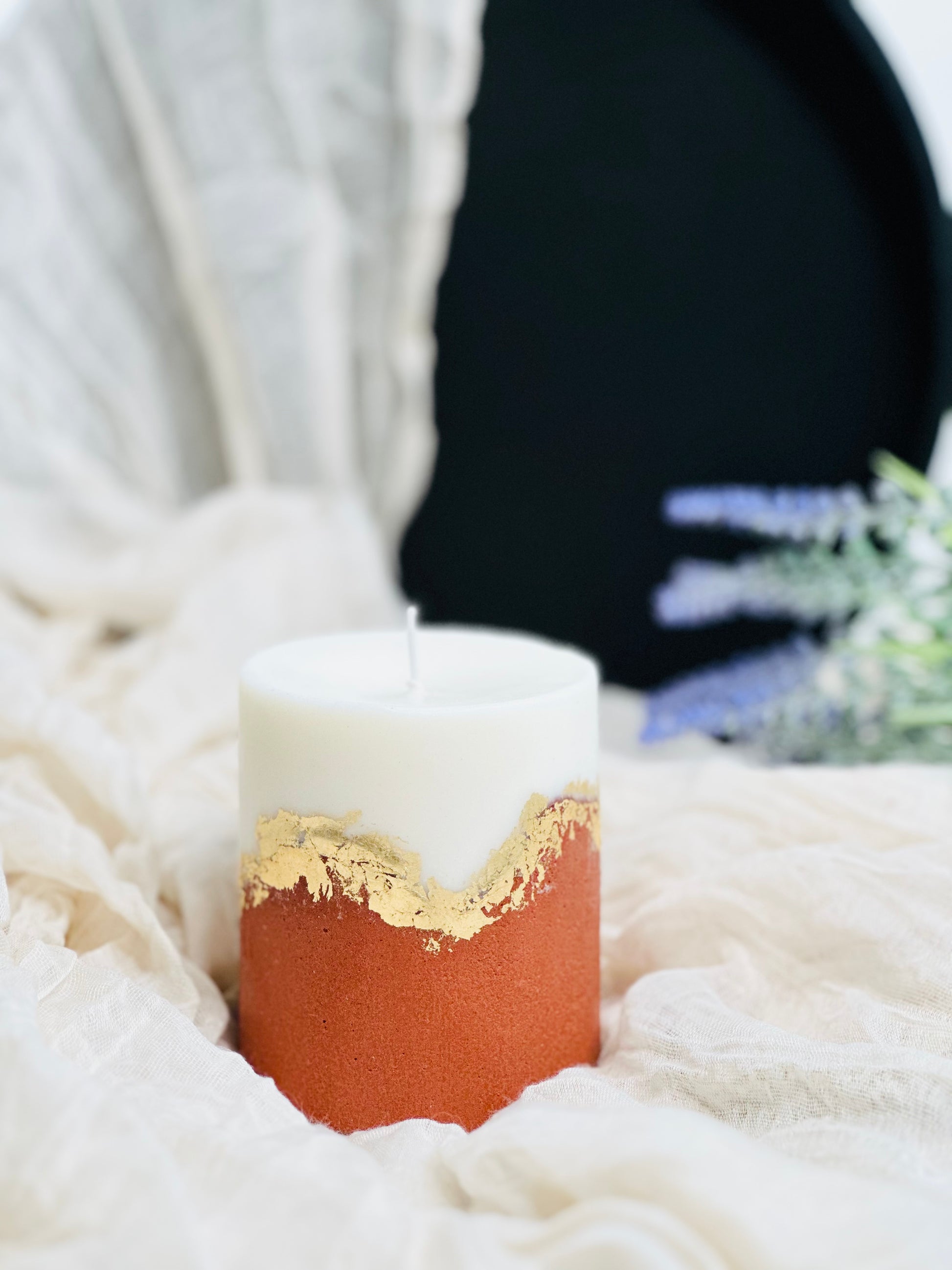 Candle with gold rim on a white surface made in UK